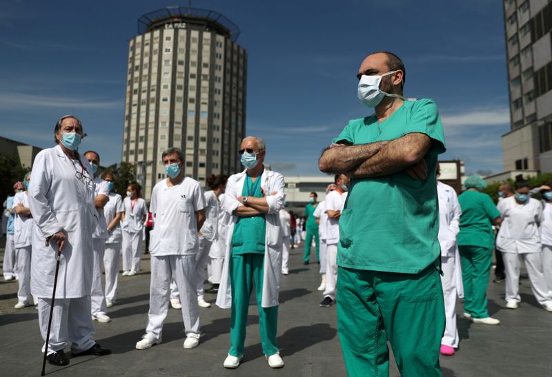 &copy; Reuters. Funcionários de hospital em Madri fazem um minuto de silêncio em homenagem a colega que morreu de Covid-19