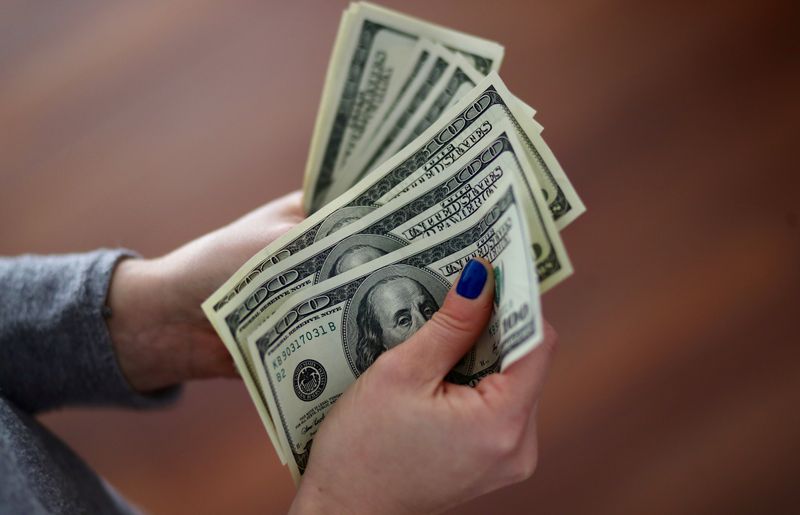 &copy; Reuters. Una donna conta una serie di banconote da 100 dollari statunitensi