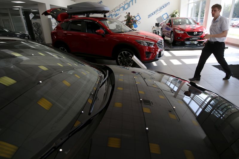&copy; Reuters. FILE PHOTO: Employee walks past Mazda Motor Co.&apos;s cars at a showroom of Avtomir company in Moscow