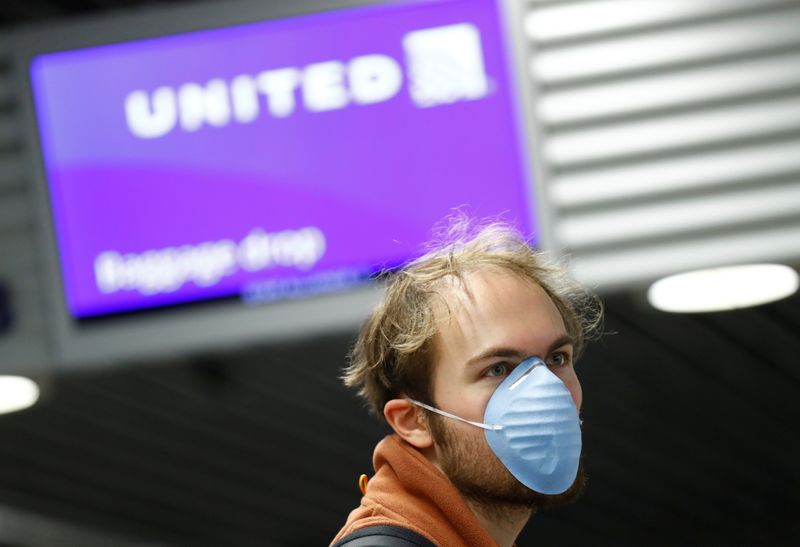 © Reuters. Passageiro com máscara de proteção contra o coronavírus em frente à área de check-in da United Airlines no aeroporto de Frankfurt, Alemanha