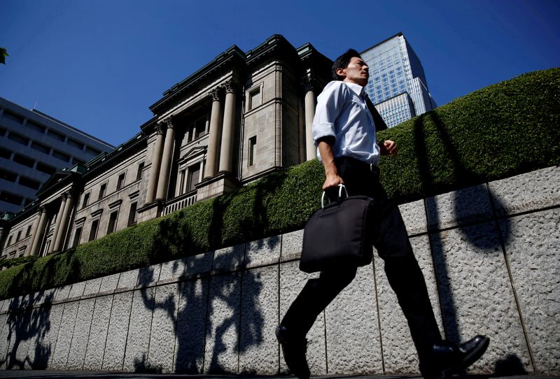© Reuters. FOTO DE ARCHIVO: Un hombre pasa corriendo por el edificio del Banco de Japón en Tokio