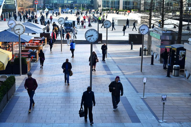 &copy; Reuters. FILE PHOTO: Commuters walk through Canary Wharf in London