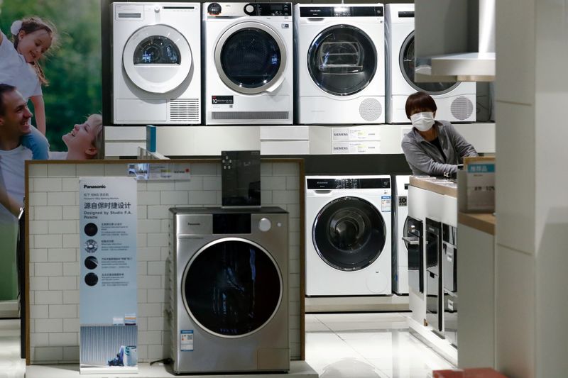 &copy; Reuters. FILE PHOTO: A woman wearing a protective mask looks at products at a home appliances retailer in Beijing