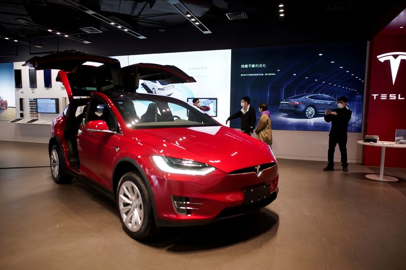 &copy; Reuters. FILE PHOTO: People wearing face masks are seen inside a Tesla showroom at a shopping mall in Wuhan