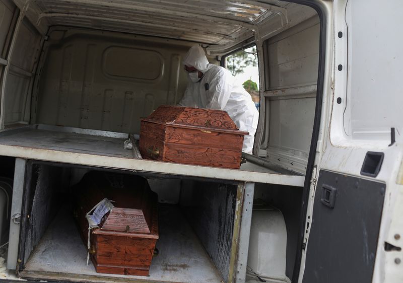 &copy; Reuters. Agente funerário retira caixões de veículo para enterros em cemitério de Manaus