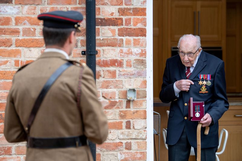 © Reuters. Former British Army Officer Captain Tom Moore, appointed the first Honorary Colonel of the Army Foundation College in Harrogate, holds his Yorkshire Regiment Medal next Lieutenant Colonel Thomas Miller in Bedford
