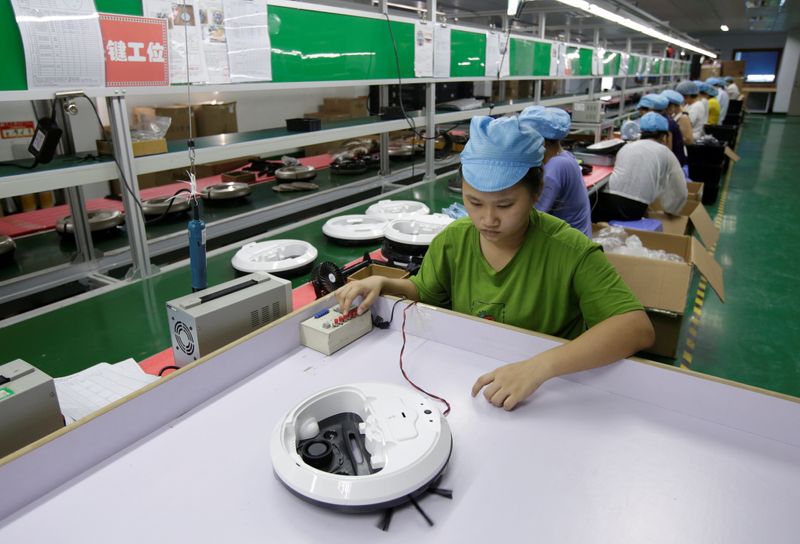 © Reuters. FOTO DE ARCHIVO: Un empleado trabaja en la línea de producción de una aspiradora robot en una fábrica de Matsutek en Shenzhen