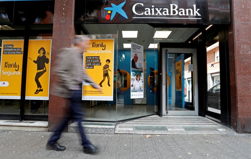 &copy; Reuters. FILE PHOTO: A man walks past a Caixa bank branch in Barcelona