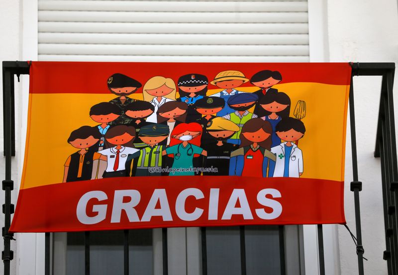 &copy; Reuters. Bandeira que homenageia funcionários de serviços essenciais em varanda em Ronda, na Espanha