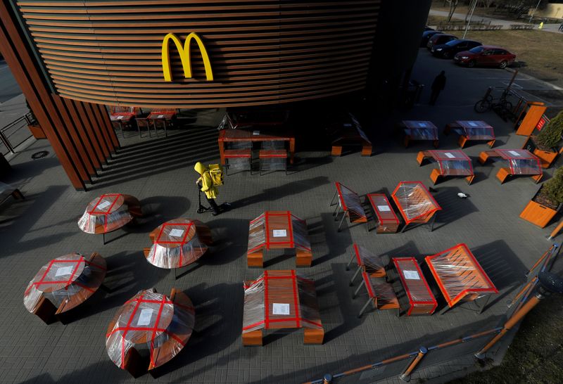 &copy; Reuters. FILE PHOTO: Food delivery courier rides a scooter among plastic-wrapped tables of McDonald&apos;s restaurant in Saint Petersburg
