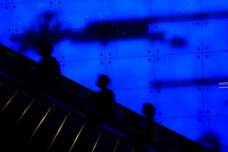 &copy; Reuters. People ride up an escalator at a shopping mall in Singapore