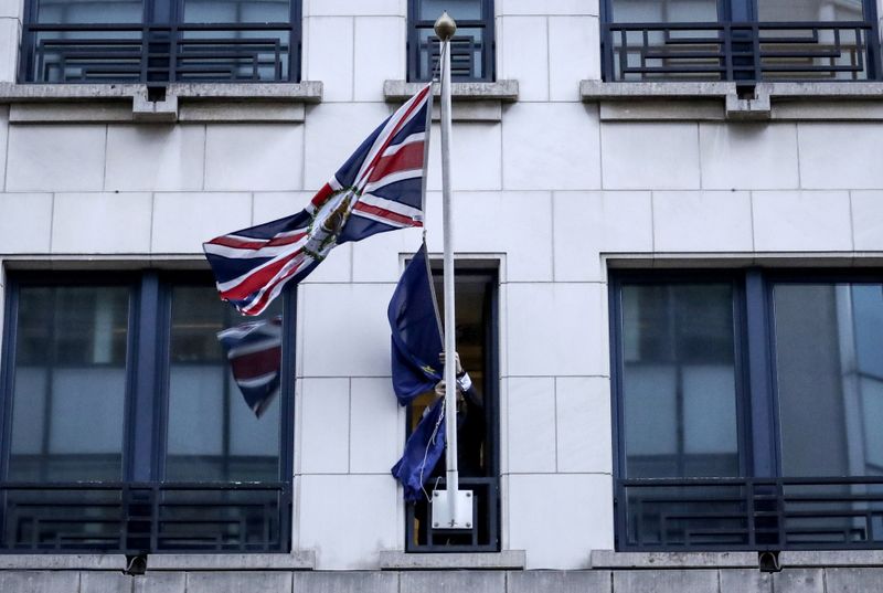 &copy; Reuters. An official removes the EU flag from Britain&apos;s Permanent Representation to the EU in Brussels