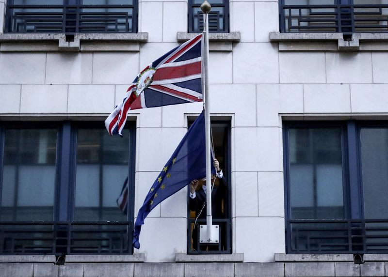 &copy; Reuters. An official removes the EU flag from Britain&apos;s Permanent Representation to the EU in Brussels