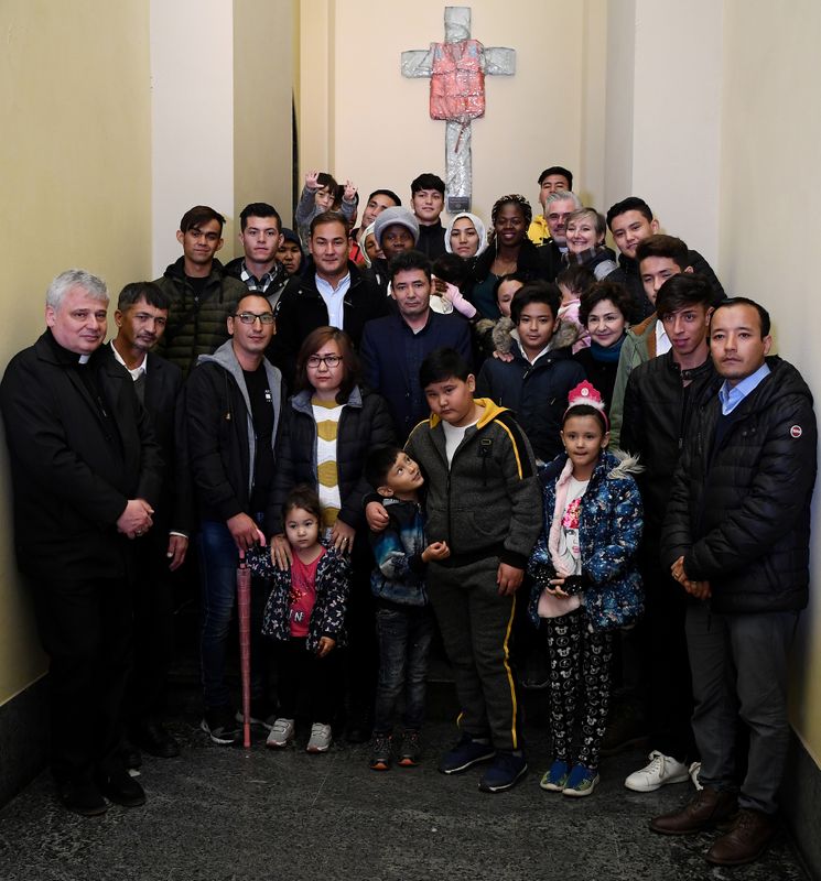 &copy; Reuters. El cardenal Konrad Krajewski posa junto a refugiados llegados desde Lesbos después de una audiencia con el papa Francisco en el Vaticano