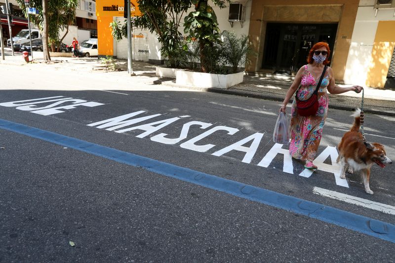 &copy; Reuters. Mulher com máscara atravessa rua em Copacabana, no Rio de Janeiro