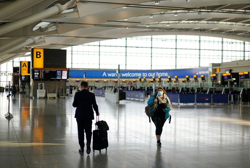 &copy; Reuters. FILE PHOTO: A woman wearing a mask is seen at Heathrow airport