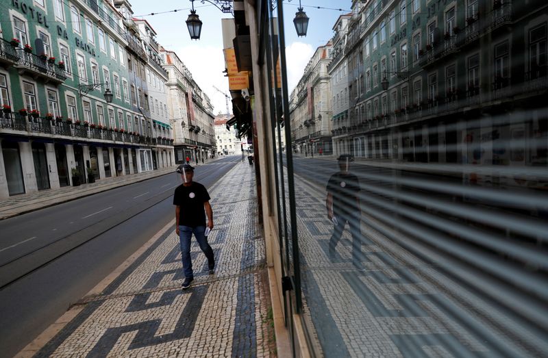 © Reuters. FILE PHOTO: A man walks down a deserted street in Lisbon, Portugal during the coronavirus outbreak