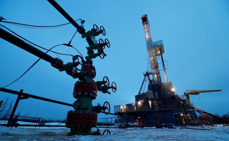 © Reuters. FILE PHOTO: A view shows a well head and a drilling rig in Irkutsk Region