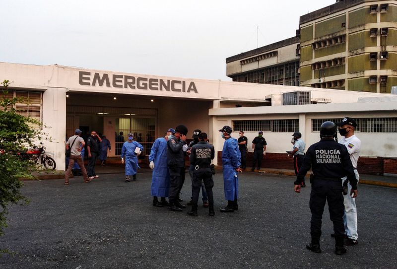 &copy; Reuters. Trabajadores sanitarios y miembros de la Policía Nacional Bolivariana fuera de un hospital después de que estallara un motín en una prisión en Guanare, Venezuela, el 1 de mayo de 2020