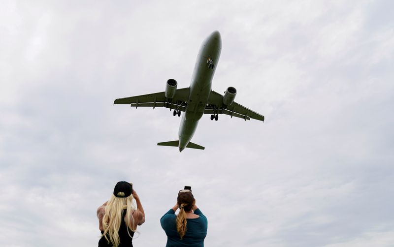 &copy; Reuters. FILE PHOTO: Flight attendants photograph a plane landing in Washington during the coronavirus crisis