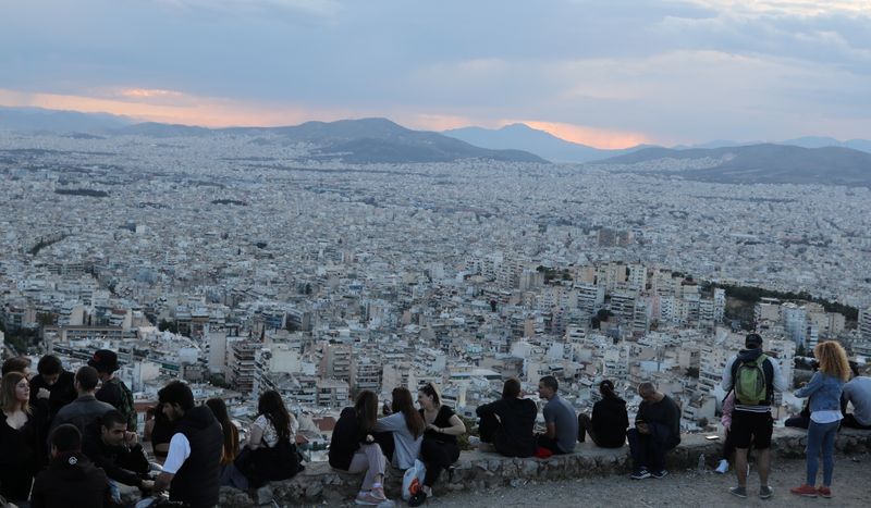 &copy; Reuters. FILE PHOTO:  People sit overlooking Athens following the coronavirus disease (COVID-19) outbreak