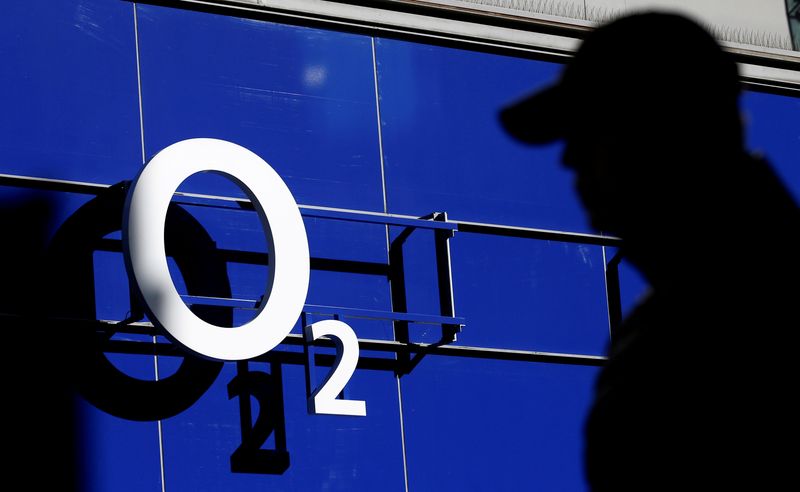 © Reuters. FILE PHOTO: A man walking past an O2 phone store in Manchester