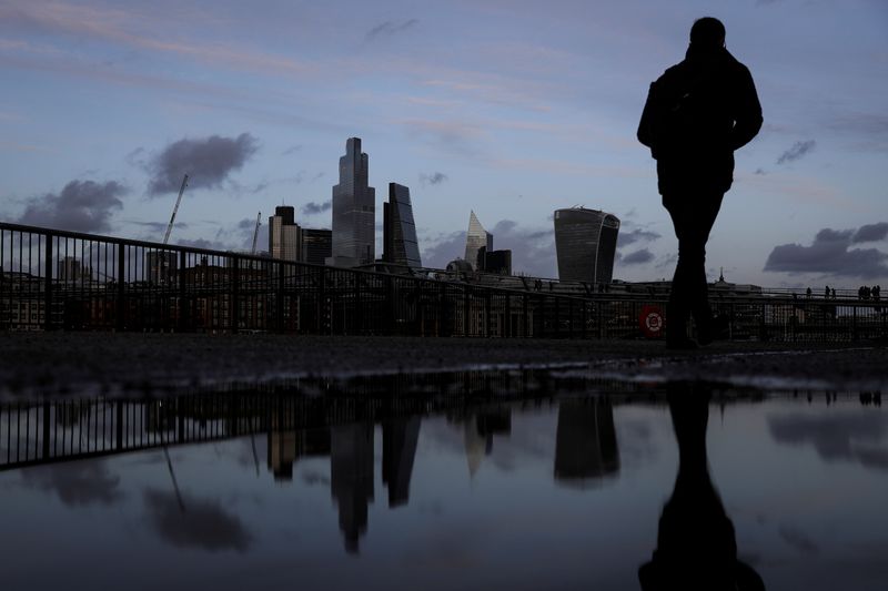 &copy; Reuters. FILE PHOTO: Pedestrians walk along the Southbank in view of skyscrapers in the financial district in London