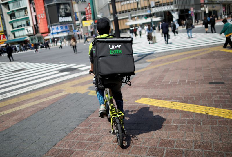 &copy; Reuters. FILE PHOTO: An Uber Eats delivery person rides a bicycle during an outbreak of the coronavirus disease, at Shibuya shopping and amusement district in Tokyo, Japan