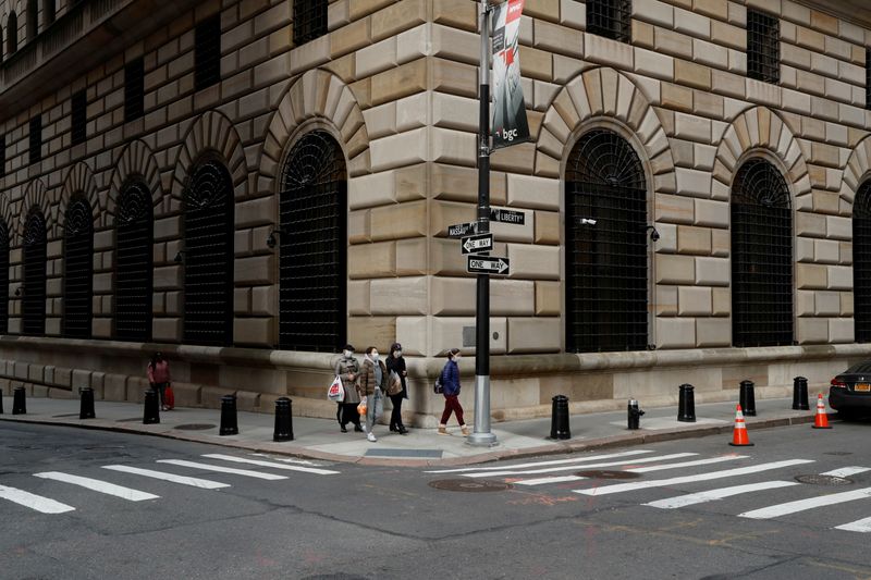 © Reuters. FOTO DE ARCHIVO: La gente camina con máscaras afuera del Banco de la Reserva Federal de Nueva York en Nueva York