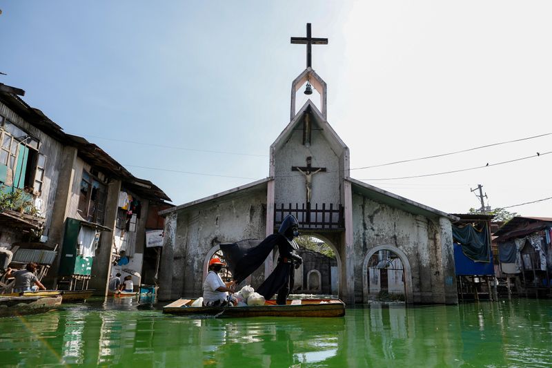 &copy; Reuters. Village officer dressed as Darth Vader delivers relief goods amid coronavirus lockdown