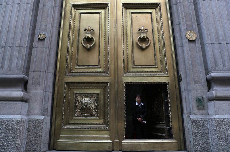 © Reuters. Entrada do banco central do Chile, em Santiago; uma funcionária aufere a temperatura de todos que chegam ao local