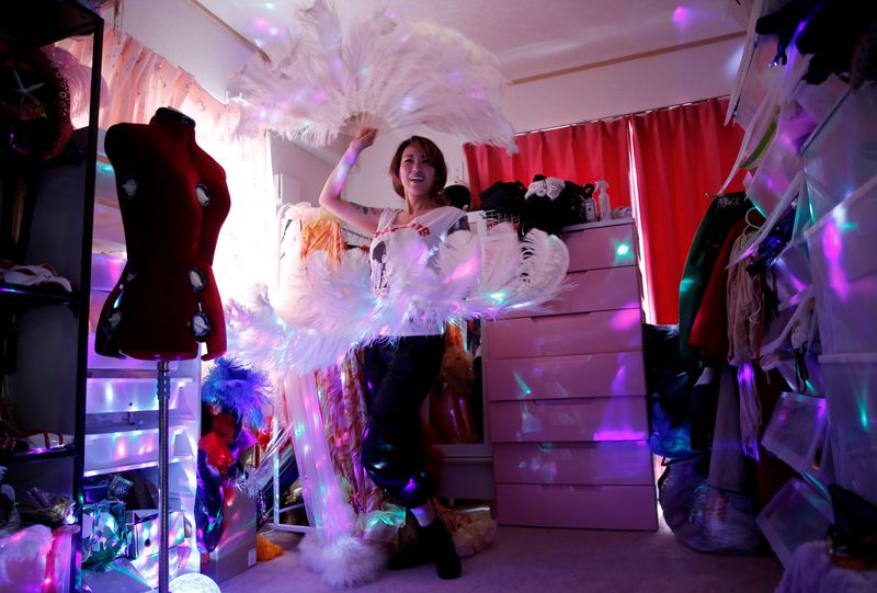 © Reuters. Burlesque show exotic dancer Aya Yumiko who performs under the name Aya Mermaid, poses with her show props at her house amid the coronavirus disease (COVID-19) outbreak, in Tokyo