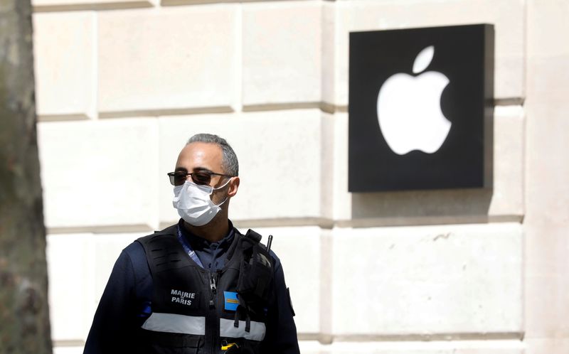 &copy; Reuters. FOTO DE ARCHIVO: Un policía municipal con una mascarilla pasa junto a una tienda de Apple cerrada en la avenida Champs-Elysees en París en medio del confinamiento parra frenar el COVID-19 en Francia. 16 de abril de 2020 .