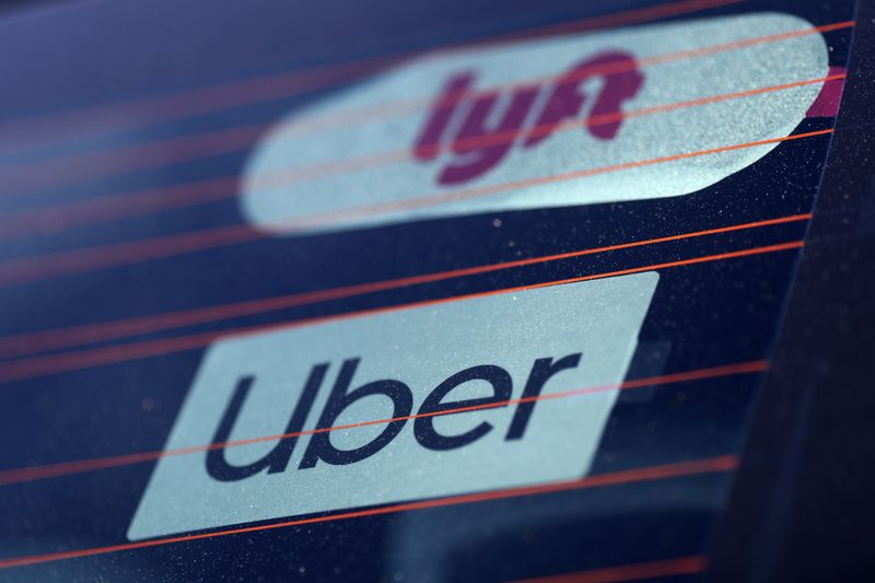 © Reuters. Uber and Lyft signs are seen on a car in Redondo Beach