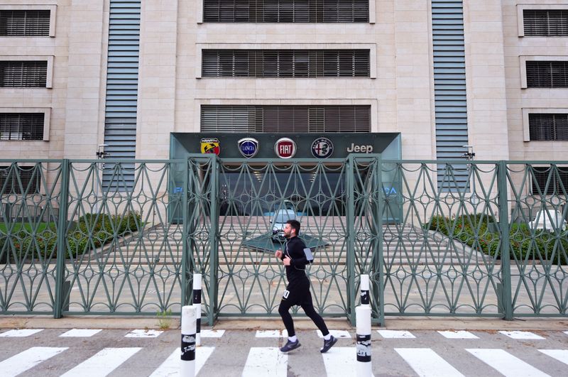 &copy; Reuters. Un uomo corre davanti l&apos;ingresso della sede centrale Fca a Torino