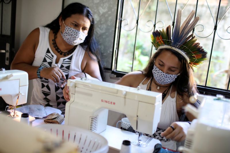 &copy; Reuters. Mulheres indígenas com máscaras de proteção fabricam máscaras em meio à pandemia de Covid-19 em Manaus