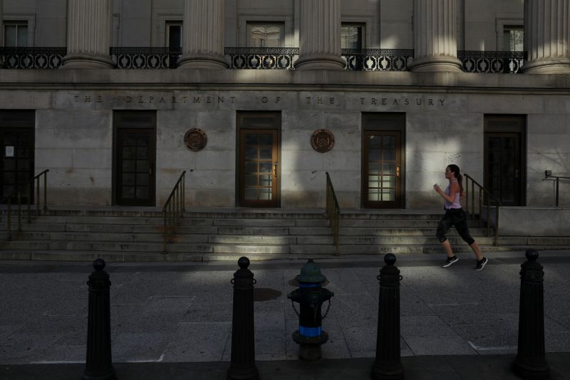 © Reuters. A woman runs on a nearly empty street in the coronavirus outbreak near the Treasury Department in Washington