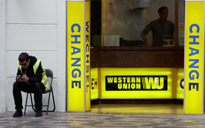 &copy; Reuters. A man sits on a chair next to Western Union currency exchange office in Prague
