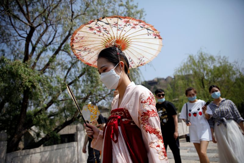 &copy; Reuters. FILE PHOTO: A woman wearing face mask and traditional Chinese clothing visits Gubei Water Town on the first day of the five-day Labour Day holiday, following the coronavirus disease (COVID-19) outbreak, on the outskirts of Beijing