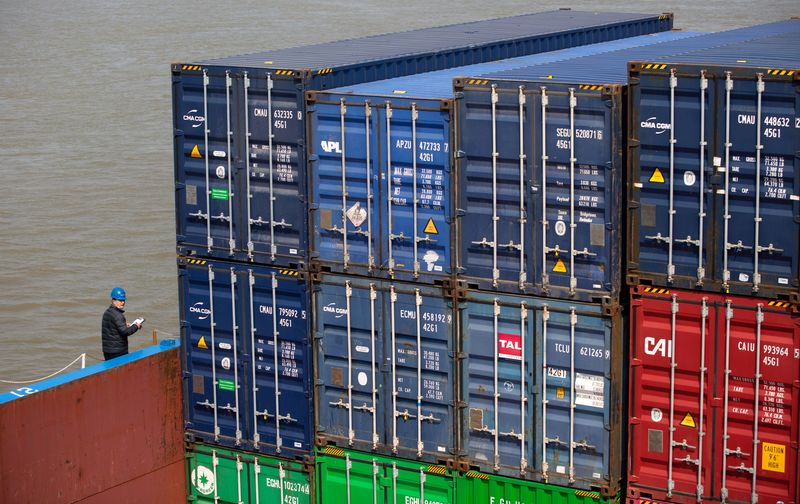 &copy; Reuters. Worker with a face mask works next to containers at a port after the lockdown was lifted in Wuhan, capital of Hubei province and China&apos;s epicentre of the novel coronavirus disease (COVID-19) outbreak