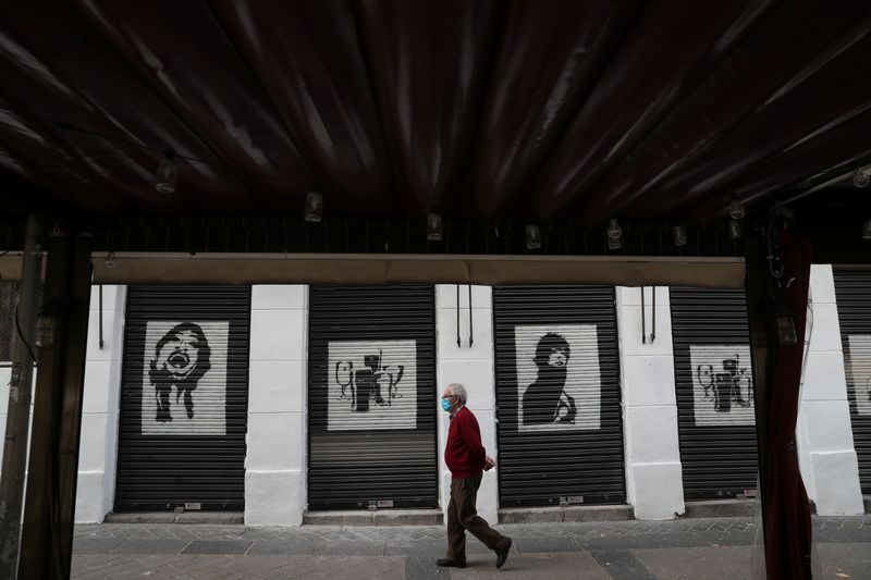 &copy; Reuters. Un anciano con una mascarilla pasa por delante de un restaurante cerrado en medio del brote de la enfermedad coronavirus (COVID-19), en Madrid, España