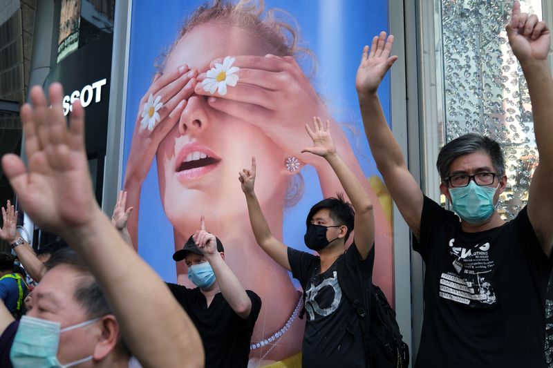 &copy; Reuters. Manifestantes antigubernamentales con mascarillas para evitar la propagación de la enfermedad coronavirus (COVID-19) levantan sus manos simbolizando las &quot;Cinco demandas, ni una menos&quot; durante una protesta, en Hong Kong