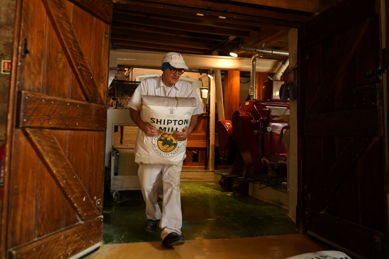 © Reuters. A worker carries a packet of flour inside the family run Shipton Mill in Tetbury