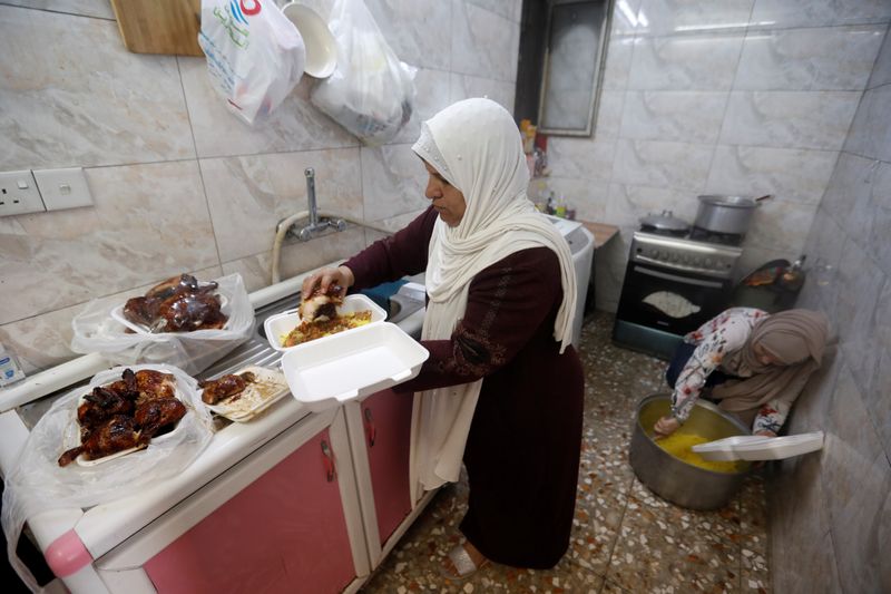 &copy; Reuters. Ikhlas Majeed, una mujer iraquí, prepara comidas para el Iftar (comida nocturna con la que se rompe el ayuno diario durante el mes islámico del Ramadán) para los fieles y las familias pobres durante el mes santo de ayuno del Ramadán, en medio de la pr