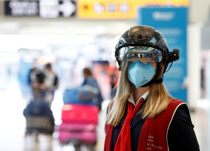 &copy; Reuters. Funcionária de aeroporto usa equipamento que mede temperatura das pessoas à distância no aeroporto de Fiumicino, em Roma