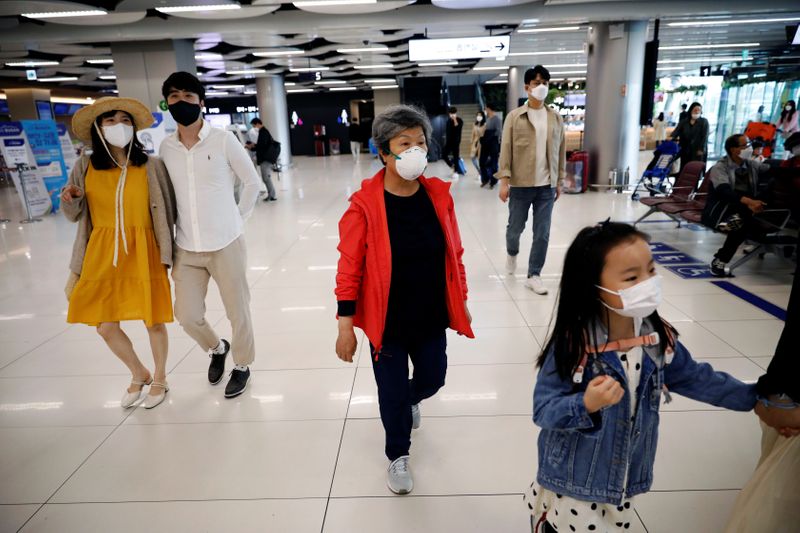 &copy; Reuters. People wearing masks to avoid the spread of the coronavirus disease (COVID-19) arrive at Gimpo international airport in Seoul