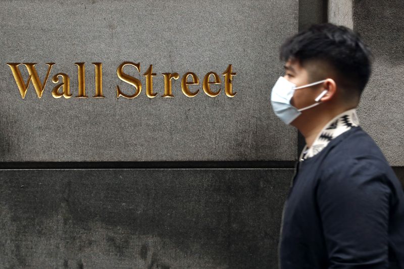&copy; Reuters. Un uomo indossa una mascherina mentre passeggia a Wall Street durante l&apos;epidemia di Coronavirus a New York