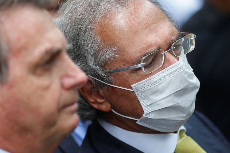 © Reuters. Brazil's Economy Minister Paulo Guedes looks on next to Brazil's President Jair Bolsonaro during a news conference, after a meeting with President of Brazil's Supreme Federal Court Dias Toffoli, amid the coronavirus disease (COVID-19) outbreak in Brasilia