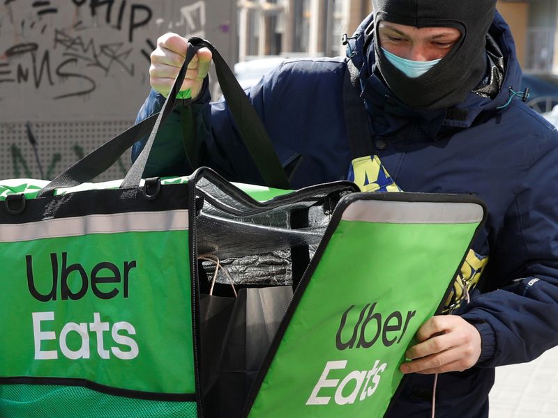 &copy; Reuters. FOTO DE ARCHIVO: Un repartidor de alimentos de Uber Eats cierra una bolsa con un pedido en Kiev