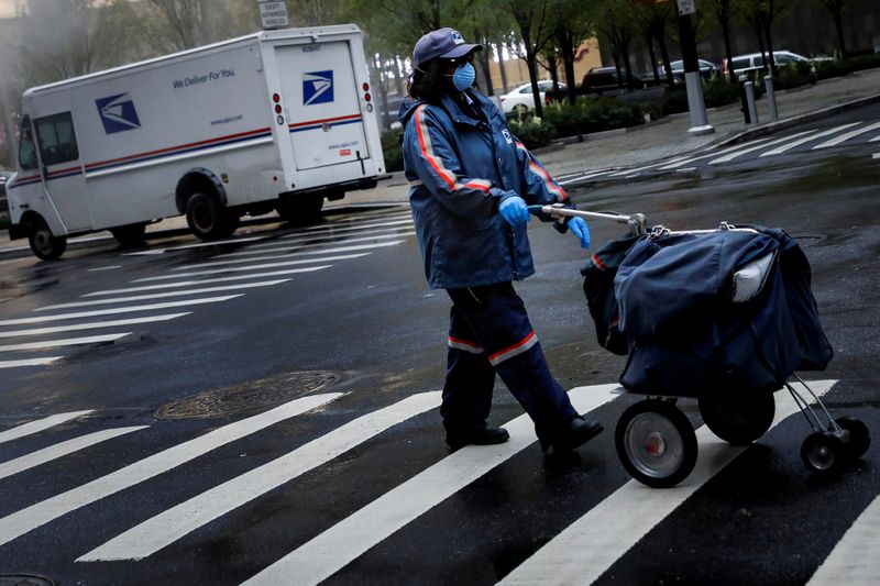 &copy; Reuters. A United States Postal Service (USPS) worker works in the rain in Manhattan during outbreak of coronavirus disease (COVID-19) in New York